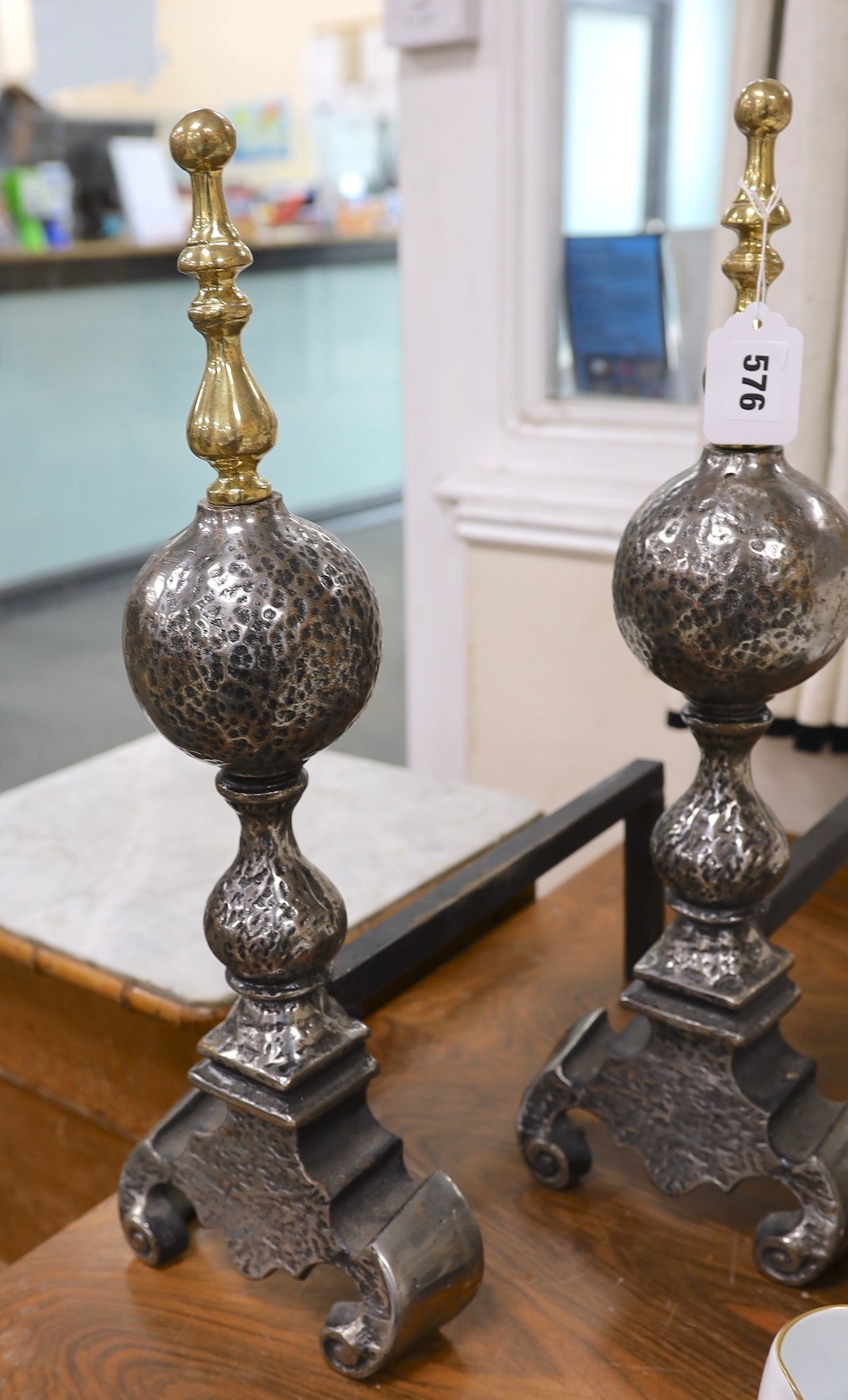 A pair of steel and brass finial fire dogs, 52cms high